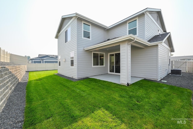 back of property with a patio area, a fenced backyard, central AC, and a yard