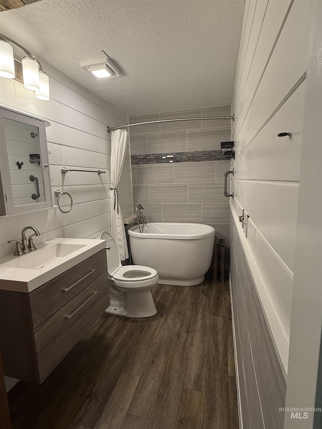 1640 N Davis Ave Unit 3, Mccall, ID 83646 - full bathroom featuring a textured ceiling, toilet, vanity, wood finished floors, and a bathtub