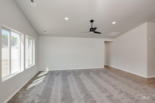 carpeted empty room featuring ceiling fan and vaulted ceiling