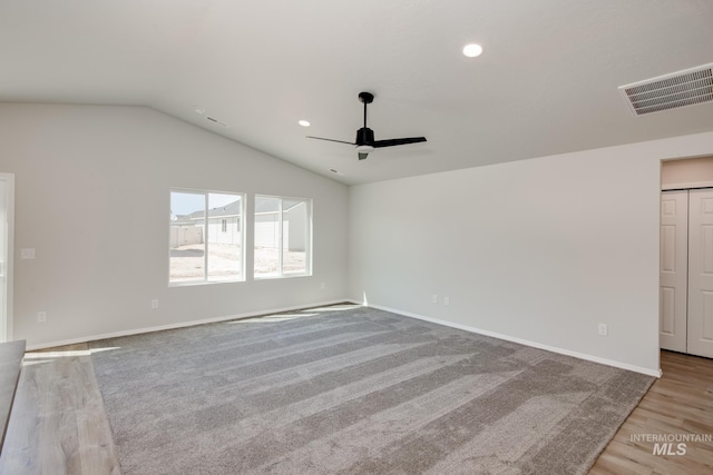 carpeted spare room with ceiling fan and lofted ceiling