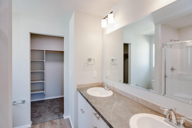 bathroom featuring wood-type flooring, toilet, and double vanity