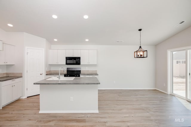 kitchen with light hardwood / wood-style flooring, range with electric cooktop, hanging light fixtures, an island with sink, and white cabinets