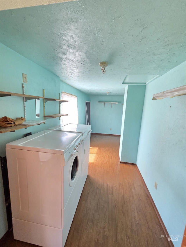 1922 9th Ave, Lewiston, ID 83501 - laundry area with washing machine and dryer, a textured ceiling, light wood-style floors, and baseboards