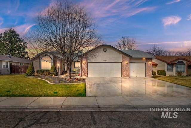 view of front of property with brick siding, a lawn, driveway, and a garage