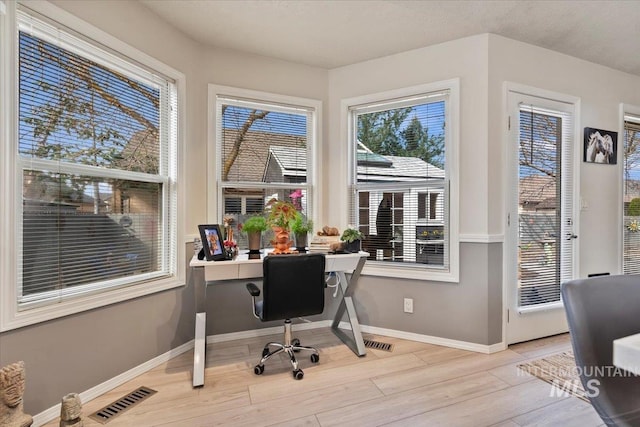 office featuring visible vents, baseboards, and wood finished floors