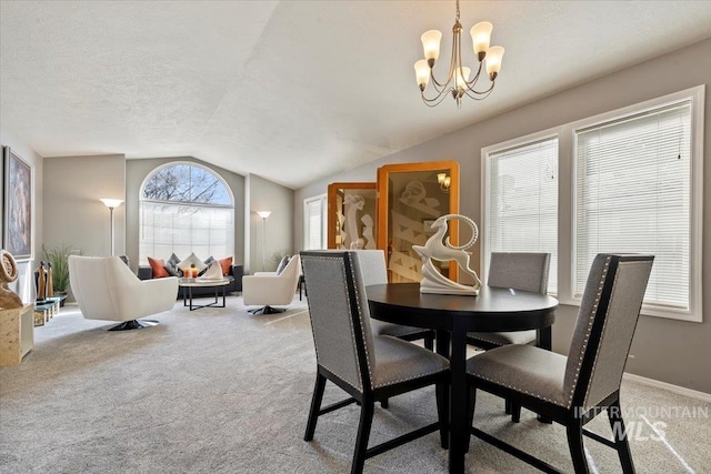 dining area with a notable chandelier, lofted ceiling, light colored carpet, and a textured ceiling