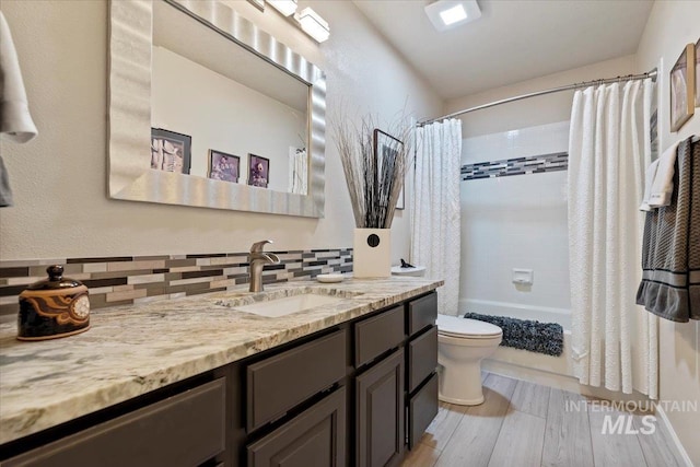 full bath with vanity, toilet, shower / bathtub combination with curtain, and tasteful backsplash