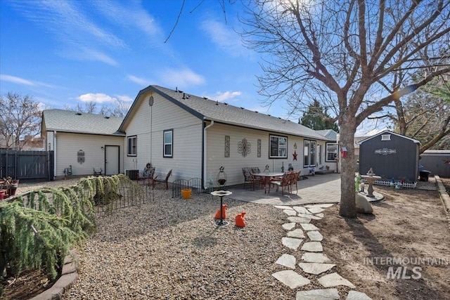 rear view of house featuring a patio, an outbuilding, central AC unit, fence, and a storage shed