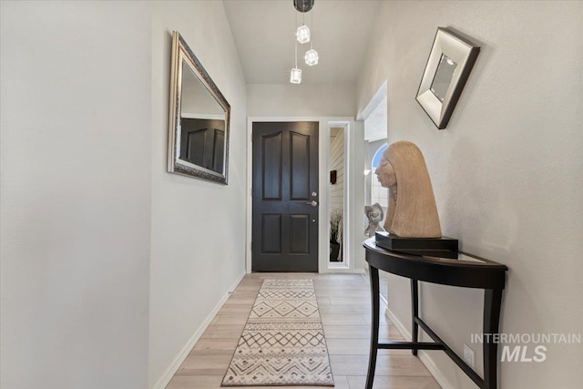 doorway featuring light wood-style flooring and baseboards