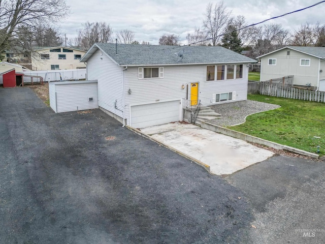 rear view of house with a garage and a yard