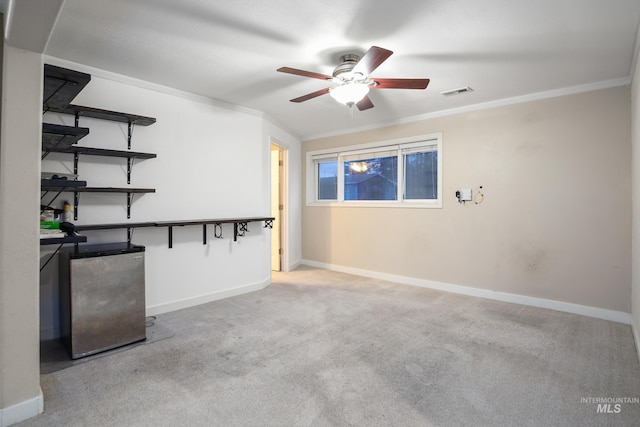 carpeted spare room with ceiling fan and ornamental molding