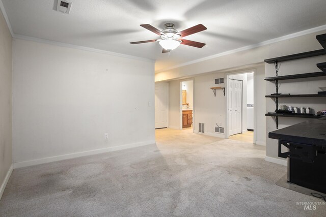 empty room with crown molding, ceiling fan, and light colored carpet