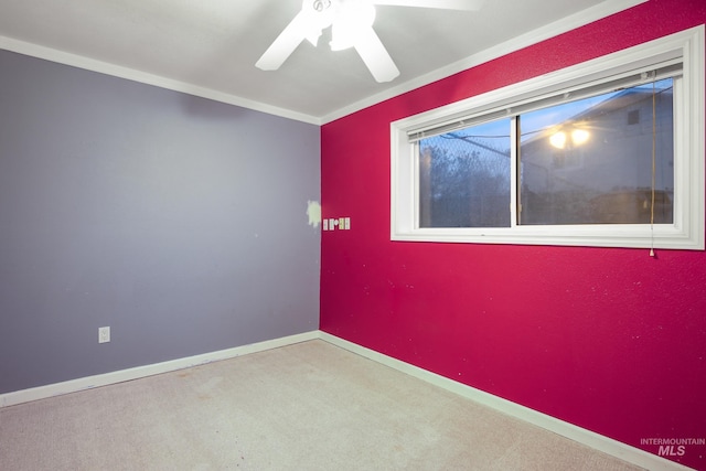 carpeted empty room featuring ceiling fan and crown molding