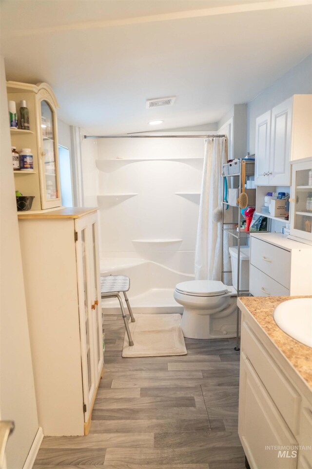 224 S Fern St, Nampa, ID 83686 - bathroom with vanity, curtained shower, toilet, and wood finished floors