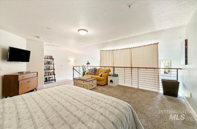 carpeted bedroom featuring baseboards and a textured ceiling