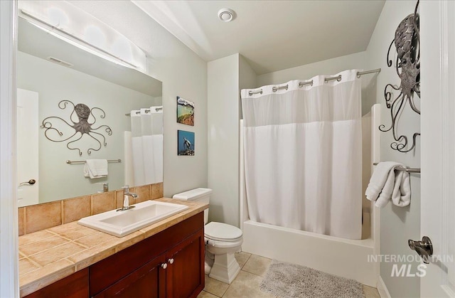 full bathroom with vanity, visible vents, shower / bath combo with shower curtain, toilet, and tile patterned floors