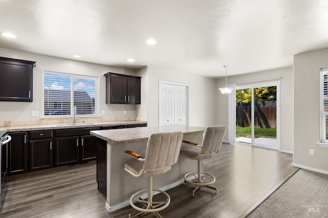 4618 Braeburn Ave, Caldwell, ID 83607 - kitchen with wood finished floors, a breakfast bar, a kitchen island, recessed lighting, and hanging light fixtures