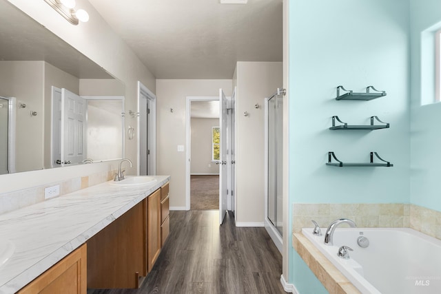 4618 Braeburn Ave, Caldwell, ID 83607 - bathroom featuring a bath, a shower stall, double vanity, and wood finished floors