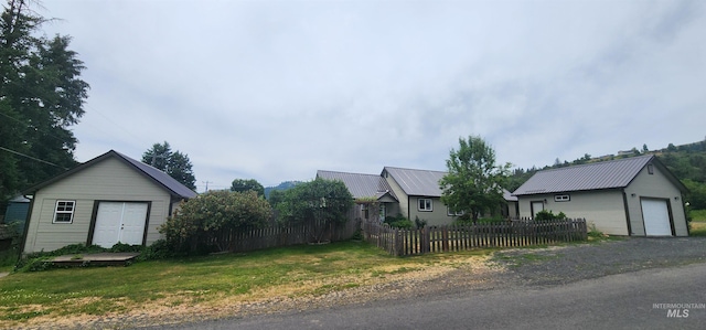 817 6th St, Kamiah, ID 83536 - view of property exterior with an outdoor structure, a detached garage, and metal roof