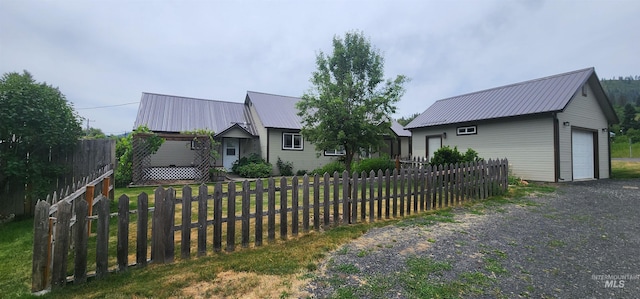 817 6th St, Kamiah, ID 83536 - single story home featuring a detached garage, metal roof, an outdoor structure, and gravel driveway