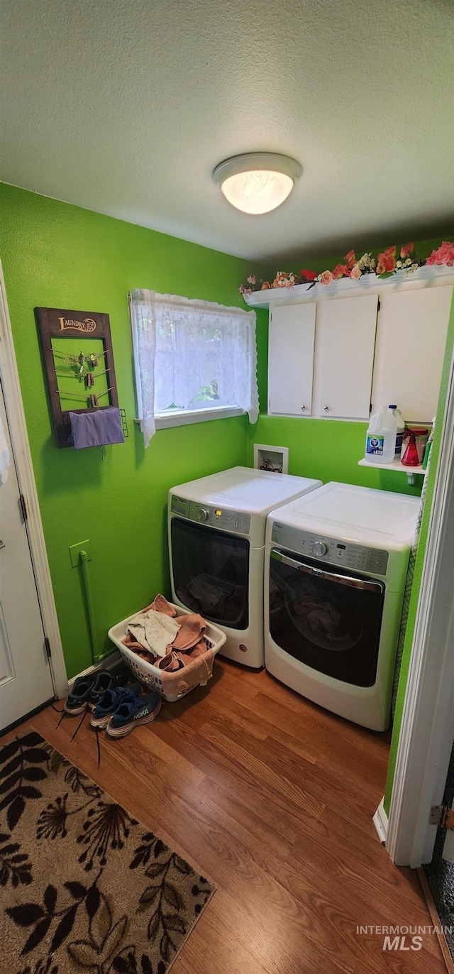 817 6th St, Kamiah, ID 83536 - laundry room with cabinet space, washer and clothes dryer, wood finished floors, and a textured ceiling