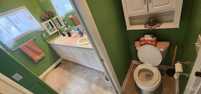 817 6th St, Kamiah, ID 83536 - bathroom featuring baseboards, toilet, double vanity, and tile patterned flooring
