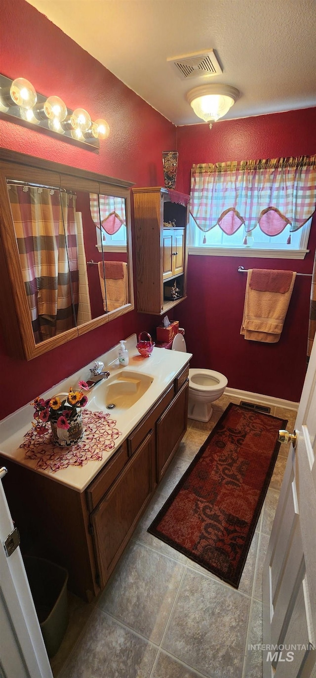 817 6th St, Kamiah, ID 83536 - bathroom with toilet, vanity, tile patterned floors, lofted ceiling, and curtained shower