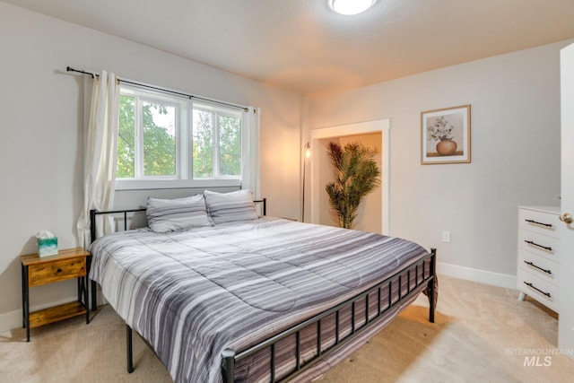 bedroom featuring baseboards and light carpet