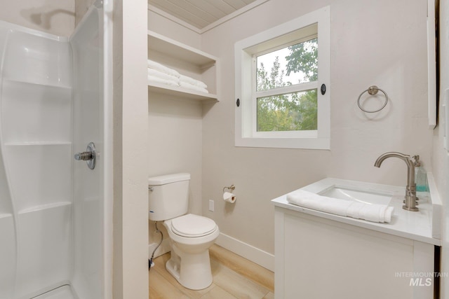 bathroom featuring a shower stall, wood finished floors, toilet, vanity, and baseboards