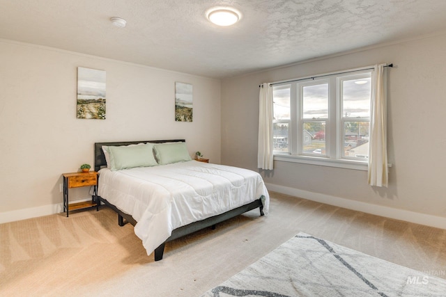 bedroom with baseboards, carpet flooring, and a textured ceiling