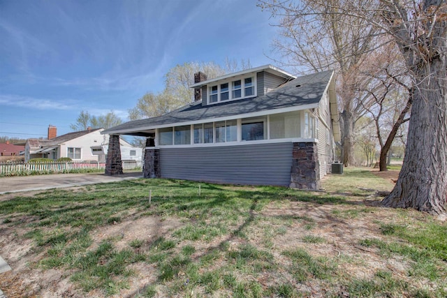 bungalow with fence, a front lawn, a chimney, and cooling unit