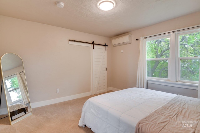 carpeted bedroom featuring a barn door, baseboards, multiple windows, and a wall mounted AC