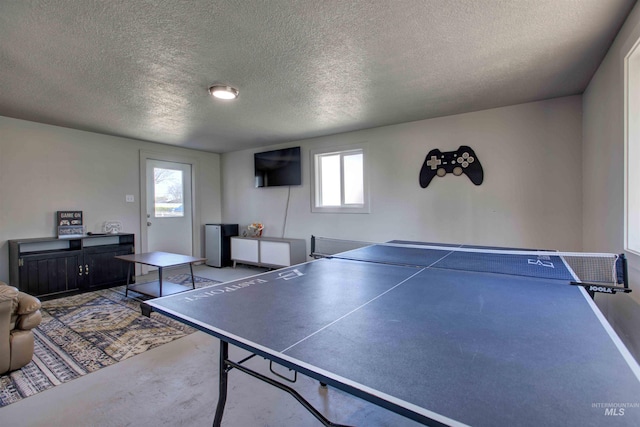 recreation room with concrete flooring and a textured ceiling