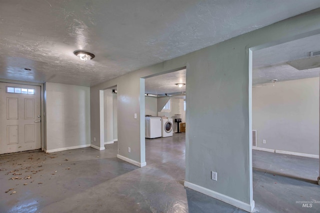 foyer with concrete floors, a textured ceiling, baseboards, visible vents, and independent washer and dryer