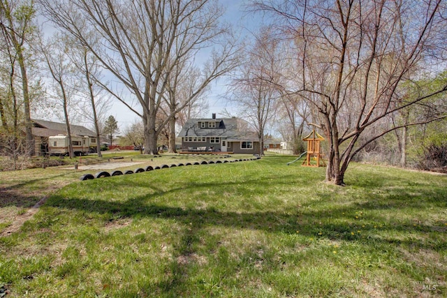 view of yard with a deck and a playground