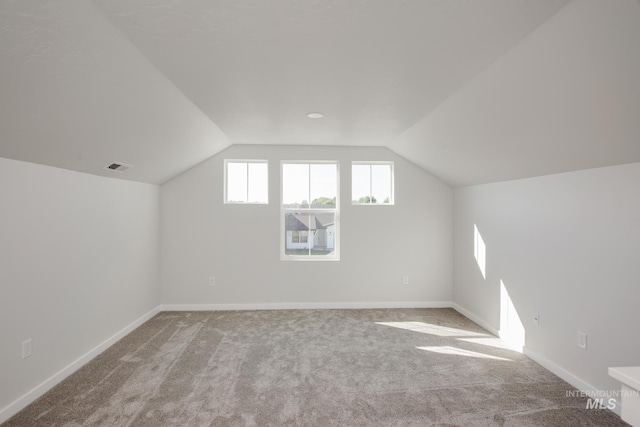 bonus room featuring light colored carpet and vaulted ceiling