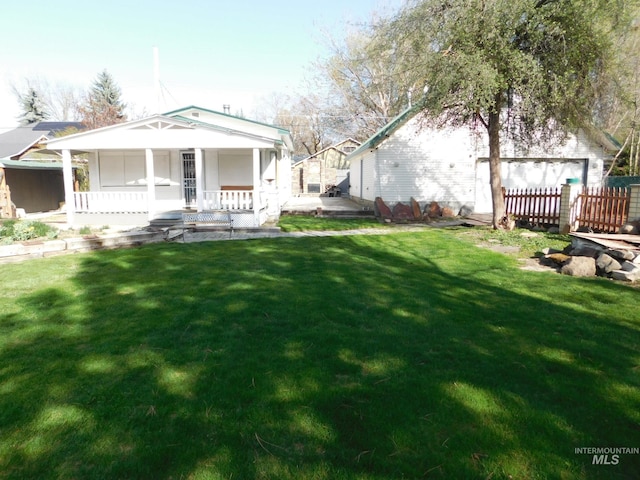 view of yard featuring fence and covered porch
