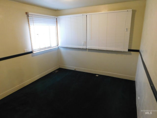unfurnished room with baseboards and visible vents