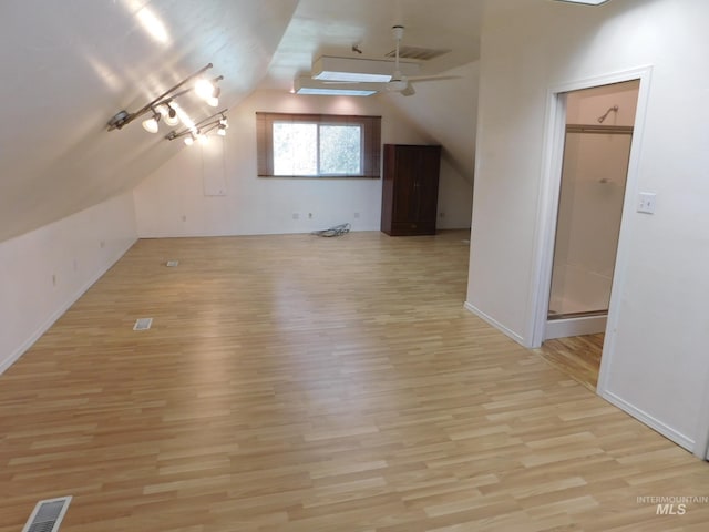 bonus room featuring light wood finished floors, baseboards, vaulted ceiling, and visible vents