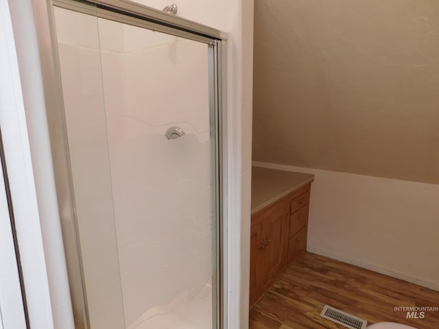full bathroom featuring visible vents, a shower stall, and wood finished floors