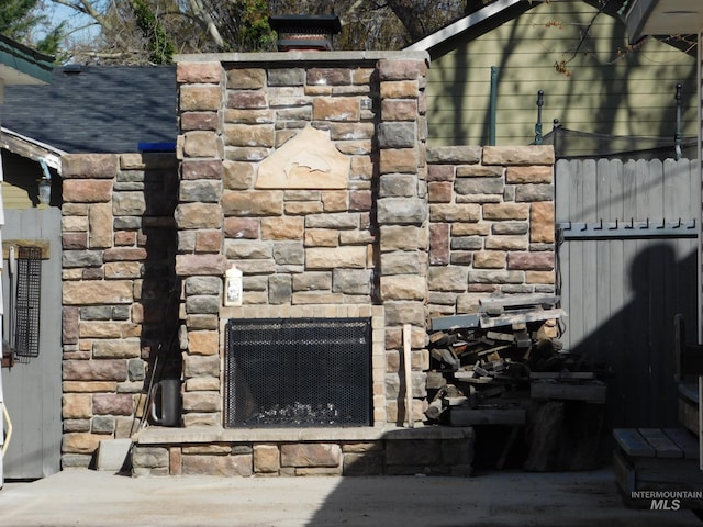 exterior details featuring stone siding and an outdoor stone fireplace