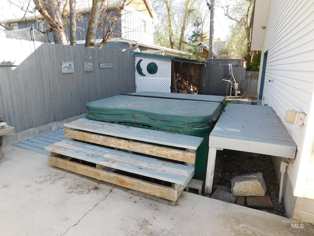 wooden deck with a fenced backyard and a covered hot tub