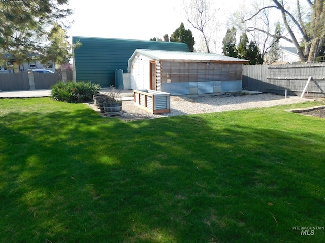exterior space with an outbuilding, fence, and a lawn