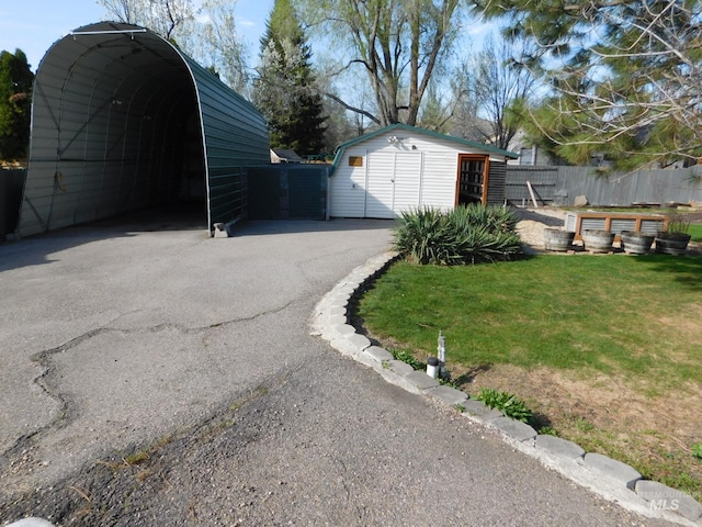 garage featuring fence and aphalt driveway
