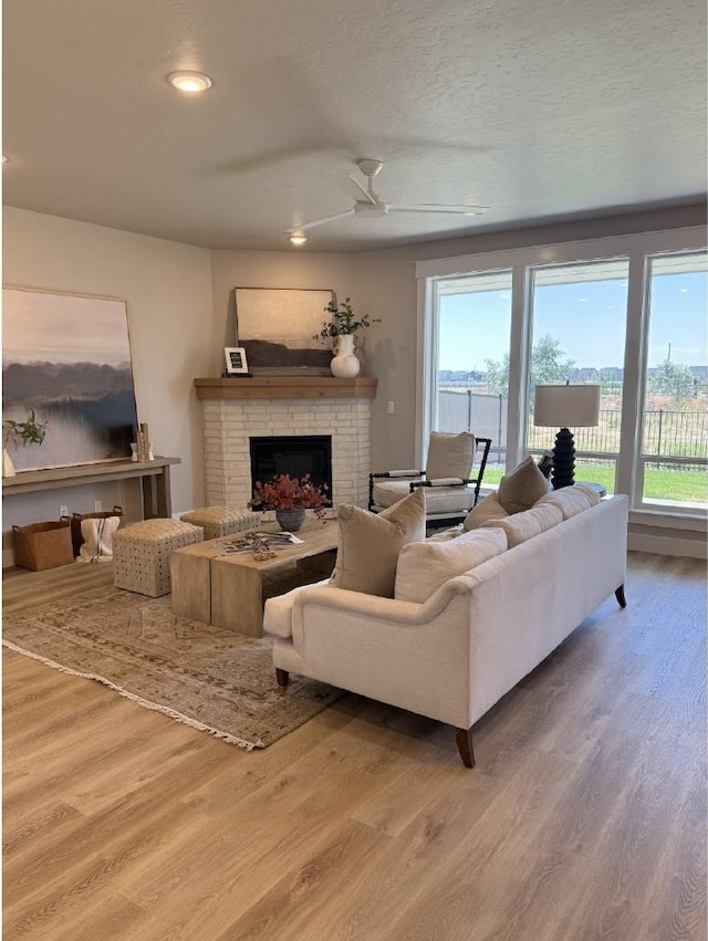 6671 W Mattawa Dr, Meridian, ID 83646 - living area featuring wood finished floors, a brick fireplace, recessed lighting, and ceiling fan
