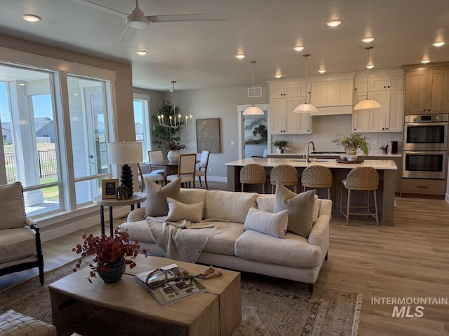 6671 W Mattawa Dr, Meridian, ID 83646 - living area with healthy amount of natural light, light wood-type flooring, a ceiling fan, recessed lighting, and a chandelier