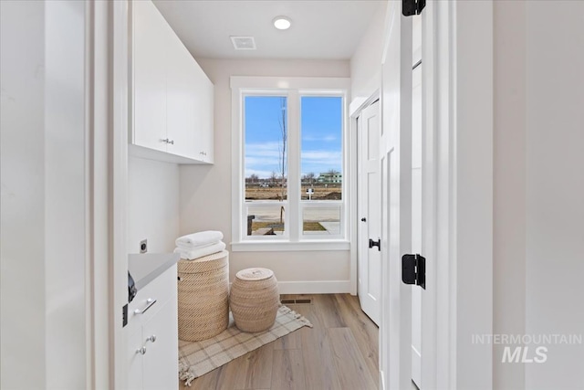 bathroom featuring visible vents, baseboards, and wood finished floors