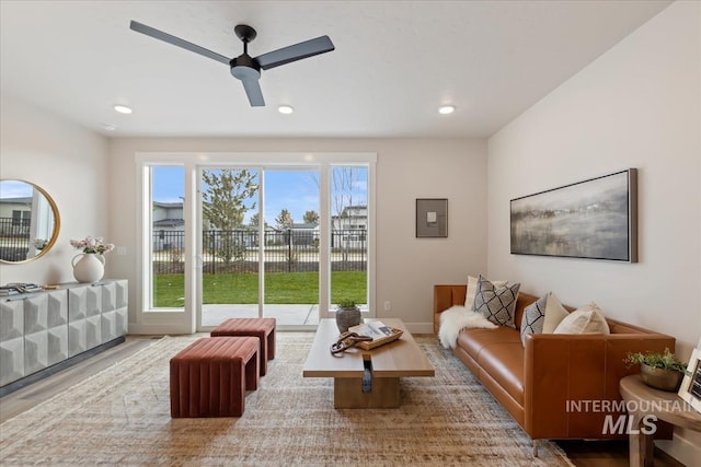 living area with a ceiling fan, recessed lighting, and baseboards