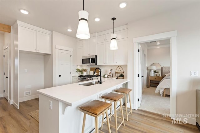 kitchen featuring light countertops, light wood-style flooring, recessed lighting, appliances with stainless steel finishes, and white cabinets