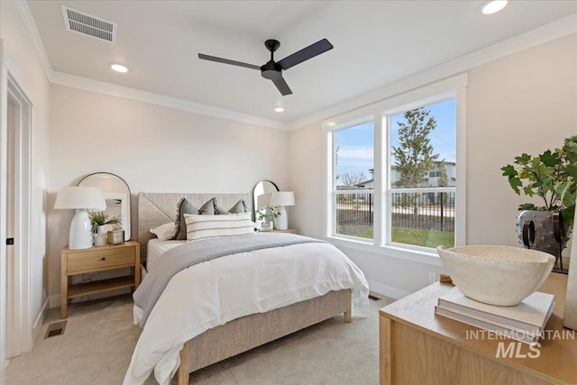 bedroom featuring visible vents, baseboards, light colored carpet, and ornamental molding